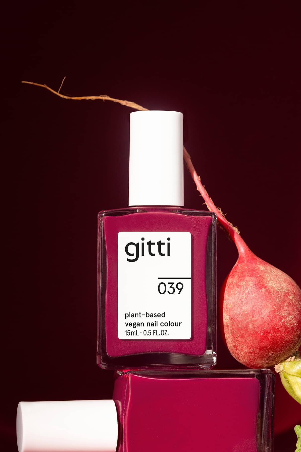 gitti nail polish bottle on a dark red background