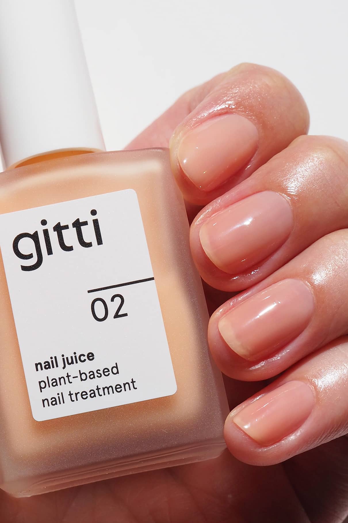 gitti nail juice treatment polish with a hand showing nails.