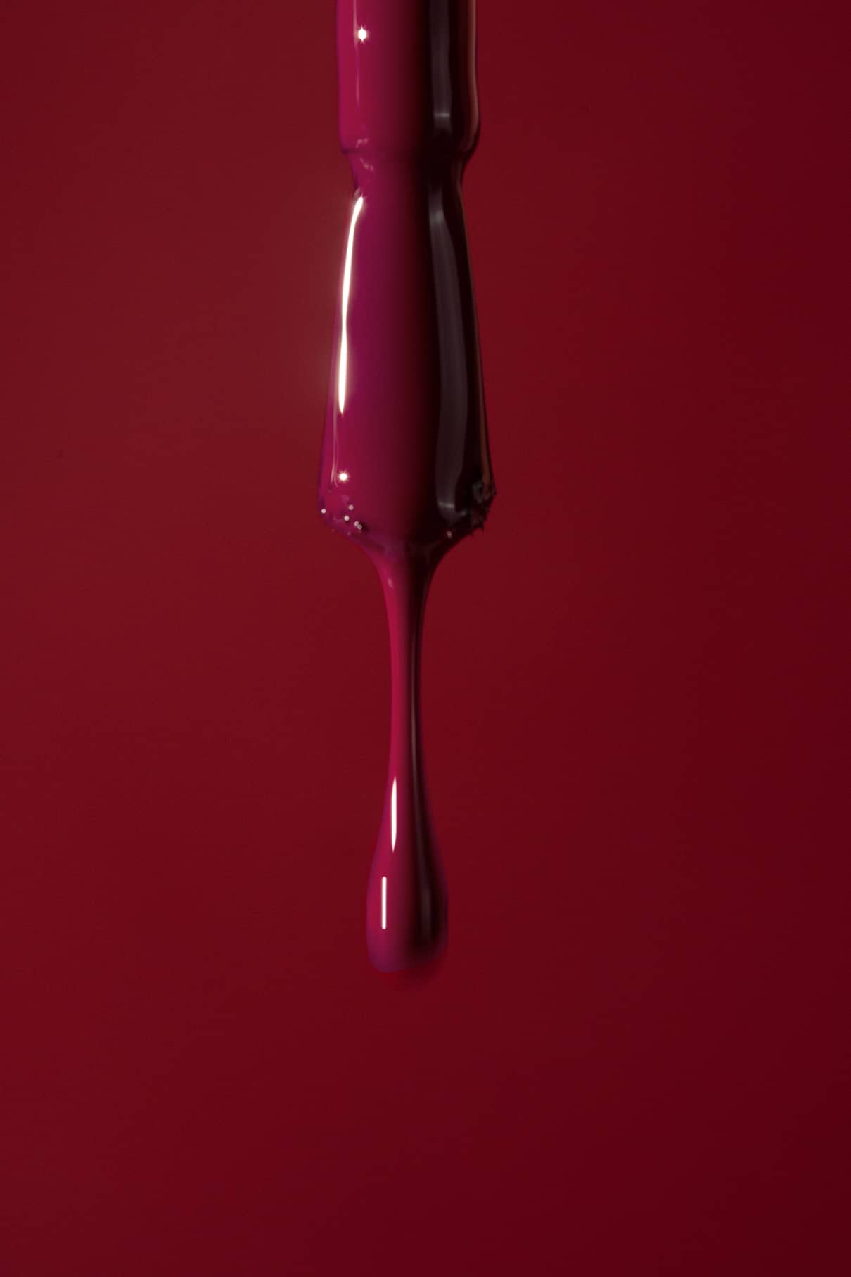 Glossy nail polish pinsel on a red background