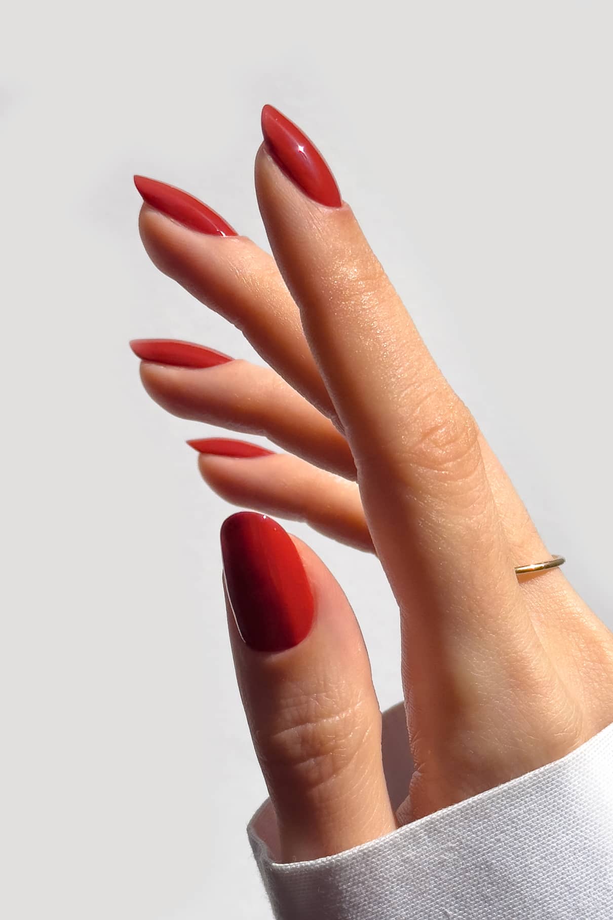 Hand with red nail polish on a white background