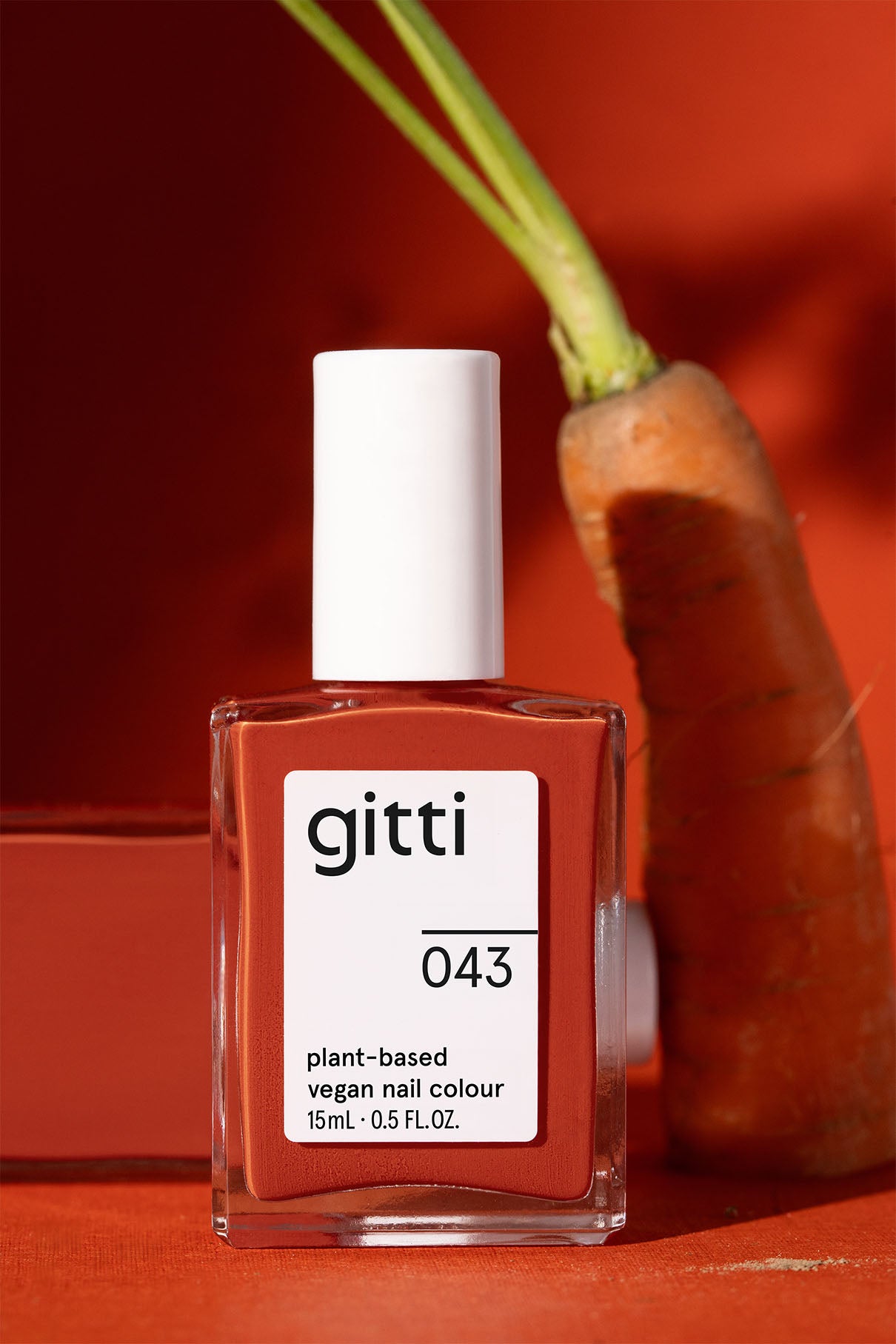 gitti plant-based vegan nail polish bottle with a carrot on an orange background