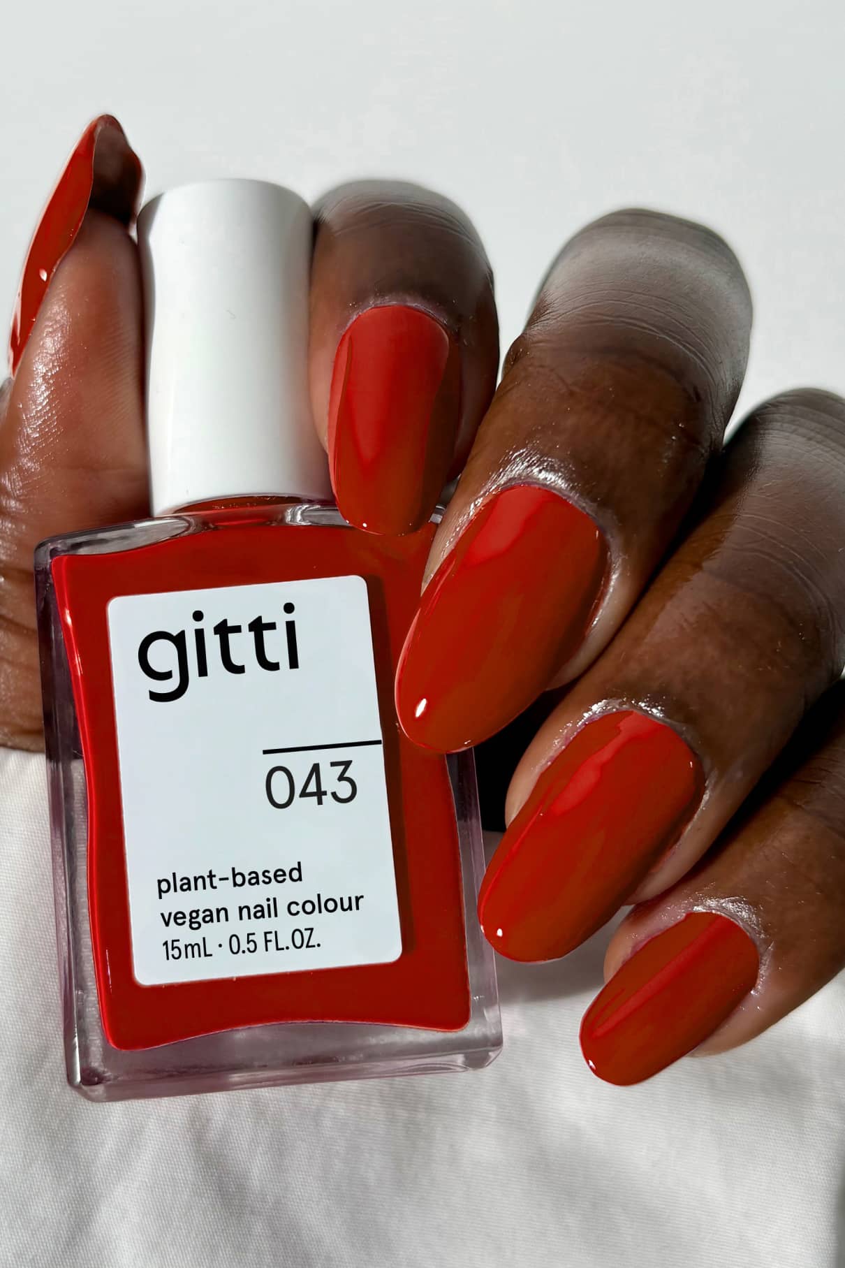 gitti nail polish bottle with matching red nails